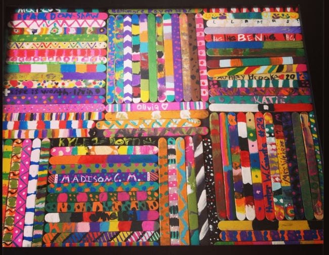 Many decorated popsicle sticks are shown arranged.