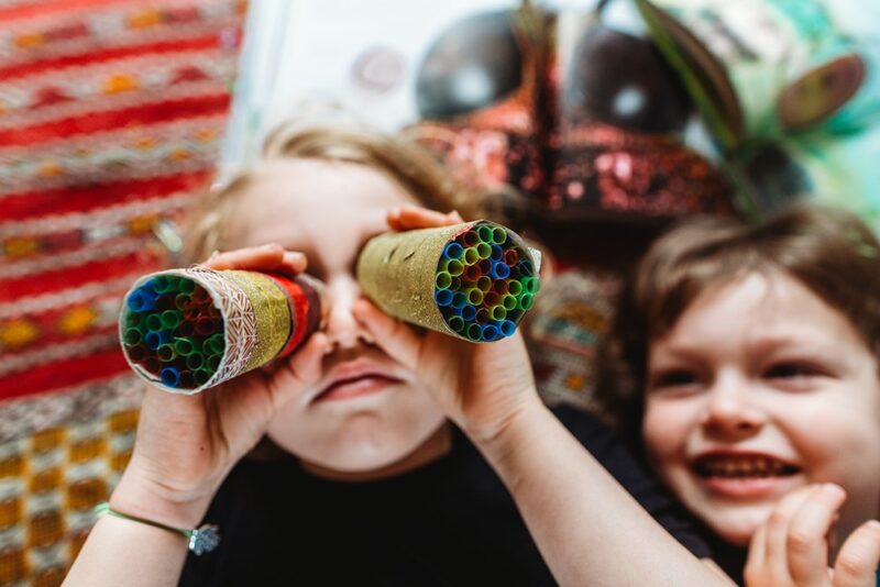 A young student looks through insect goggles made from toilet paper rolls and straws