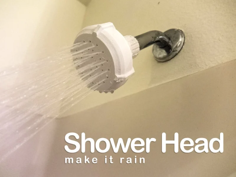 A white shower head is shown with water coming out in this example of 3D printing ideas.