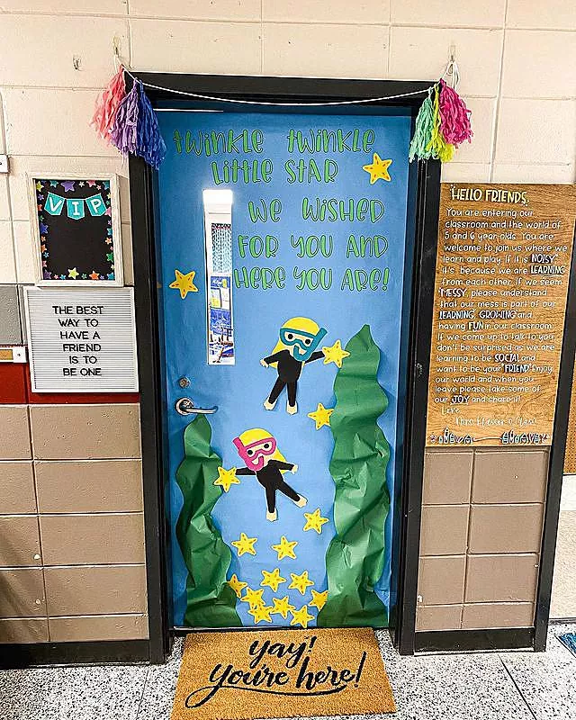A classroom door reads twinkle twinkle little star we wished for you and you are here. It features underwater divers diving for starfish.