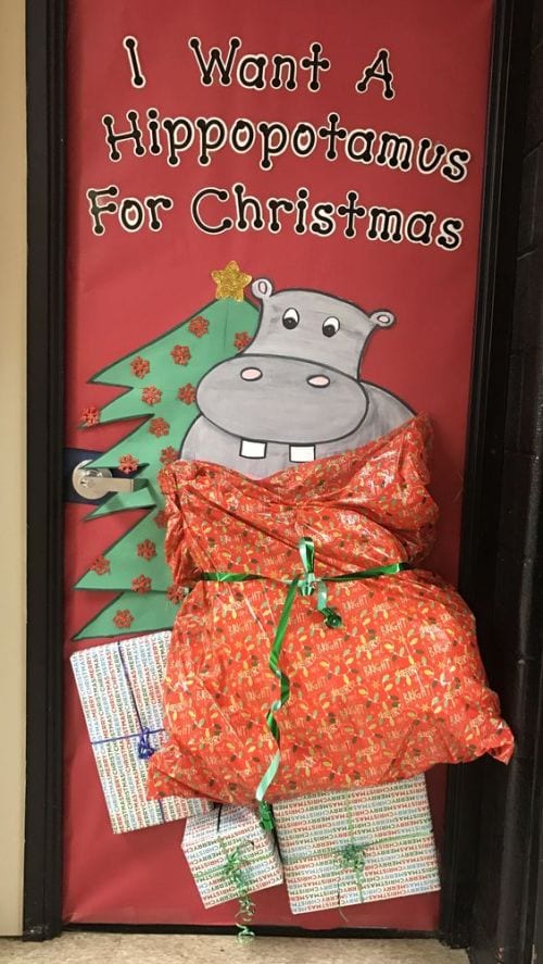 Classroom door decorated with a hippo in a large bag by a Christmas tree. Text reads 