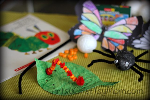 The Very Hungry Caterpillar book is in the background on a table. A green leaf has a caterpillar on it that is constructed from a red pipe cleaner and beads in this example of very hungry caterpillar activities.