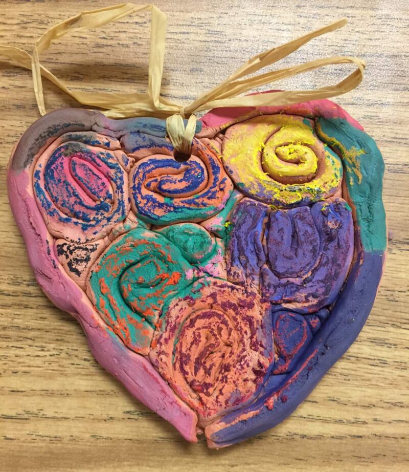 Heart made by coiling clay into spirals and adding color with paints