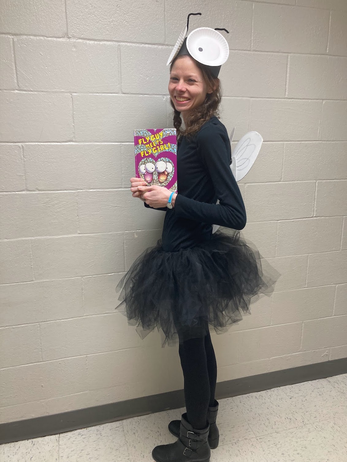 Teacher dressed as Fly Guy and holding the picture book