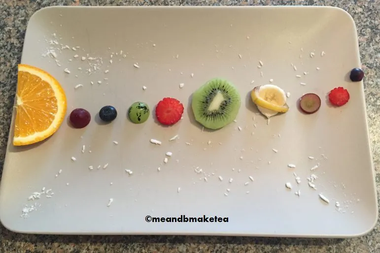 Pieces of fruit lined up by size in a solar system model