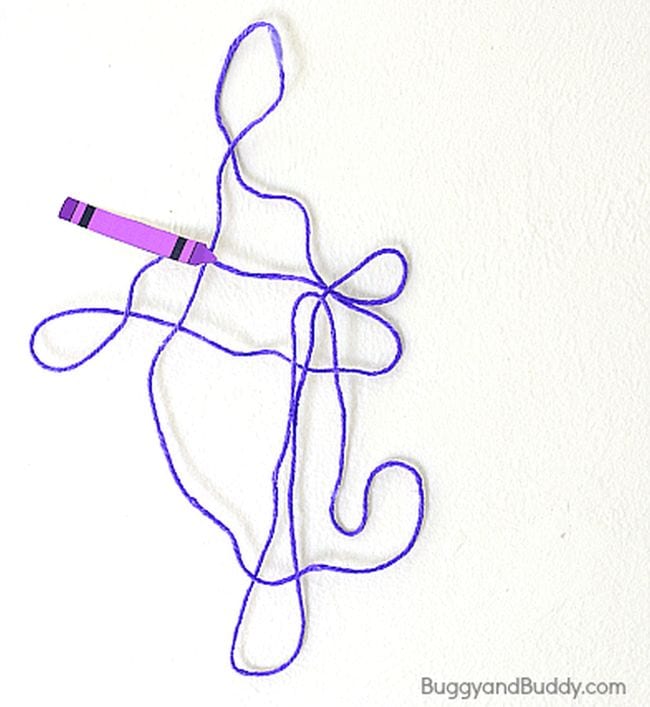 Purple yarn stiffened and shaped into a pattern, with a paper purple crayon at one end