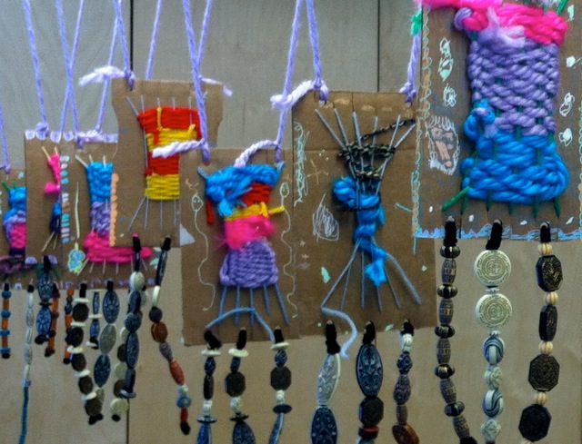 Woven design created with yarn on cardboard, with dangling beads in this example of kindergarten art projects.
