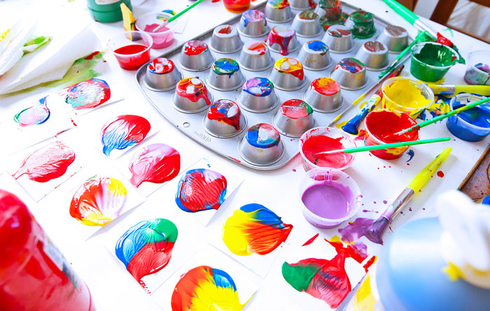 Upside-down muffin tins used to make colorful paint prints