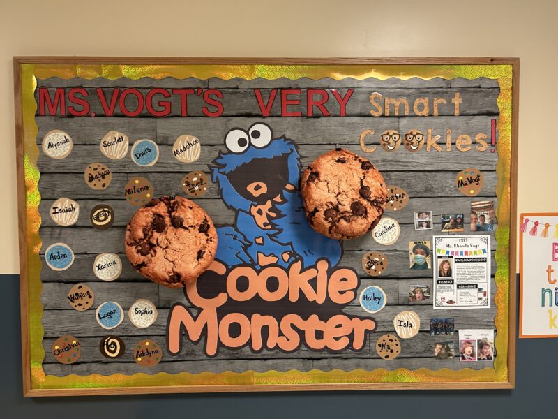 A bulletin board has cookie monster in the middle. there are cookies throughout with students names on it.