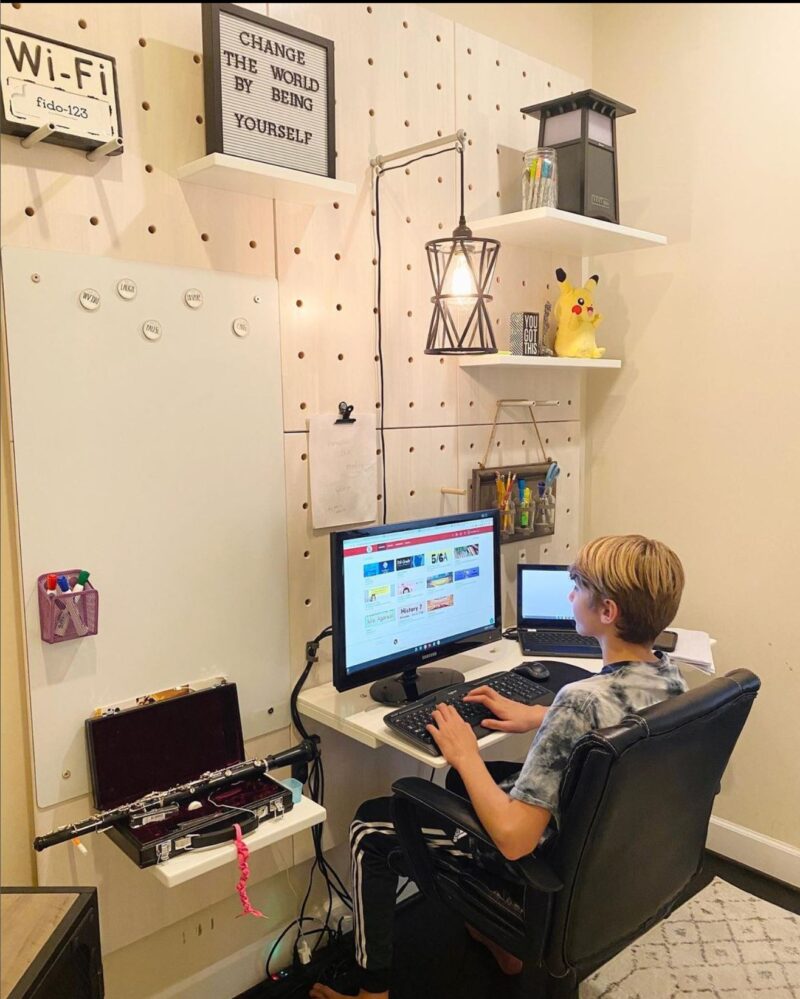 Teen boy practicing study skills on computer at his organized desk.