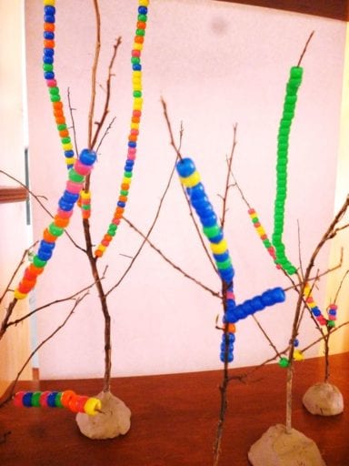 3-D trees have beads strung on them in this example of kindergarten art projects.